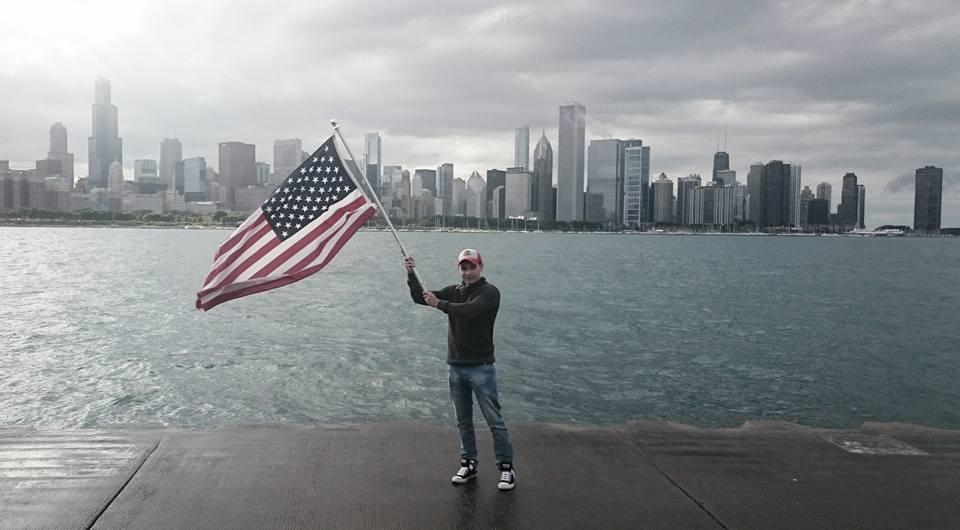 Chico alzando bandera de estados unidos