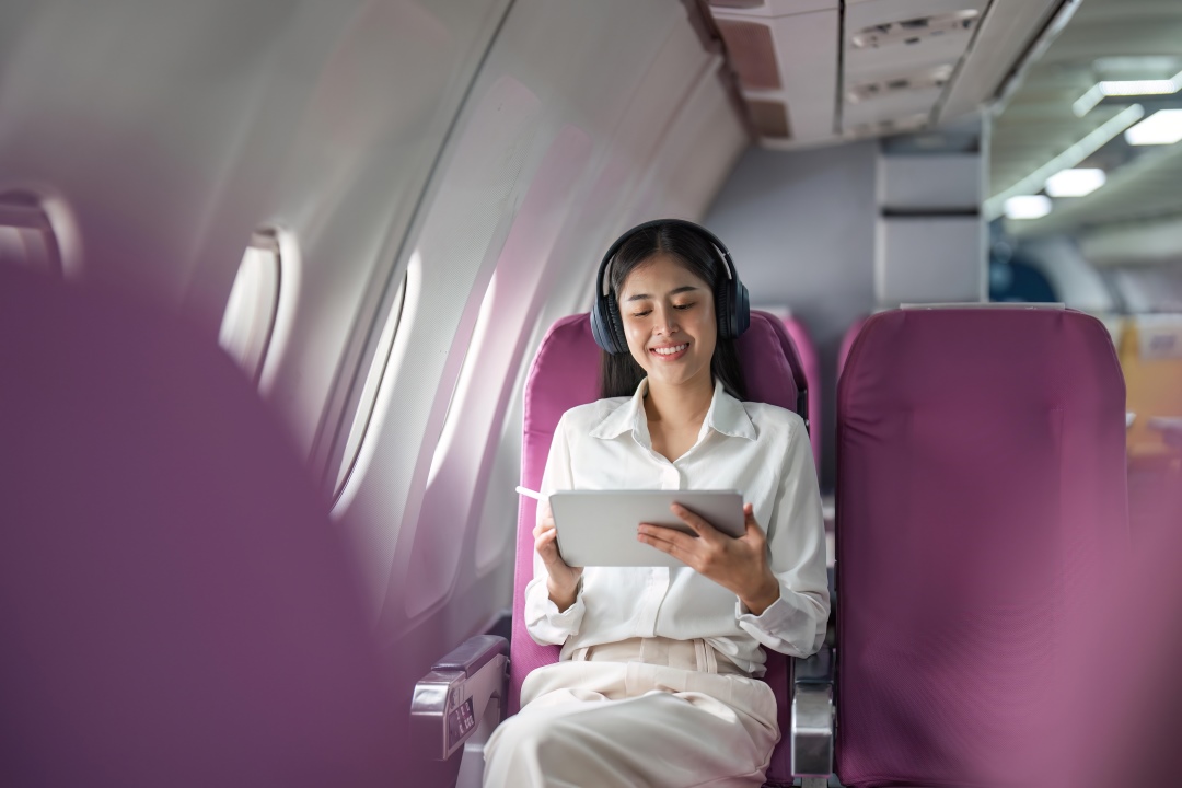 Chica en un avión con su tablet